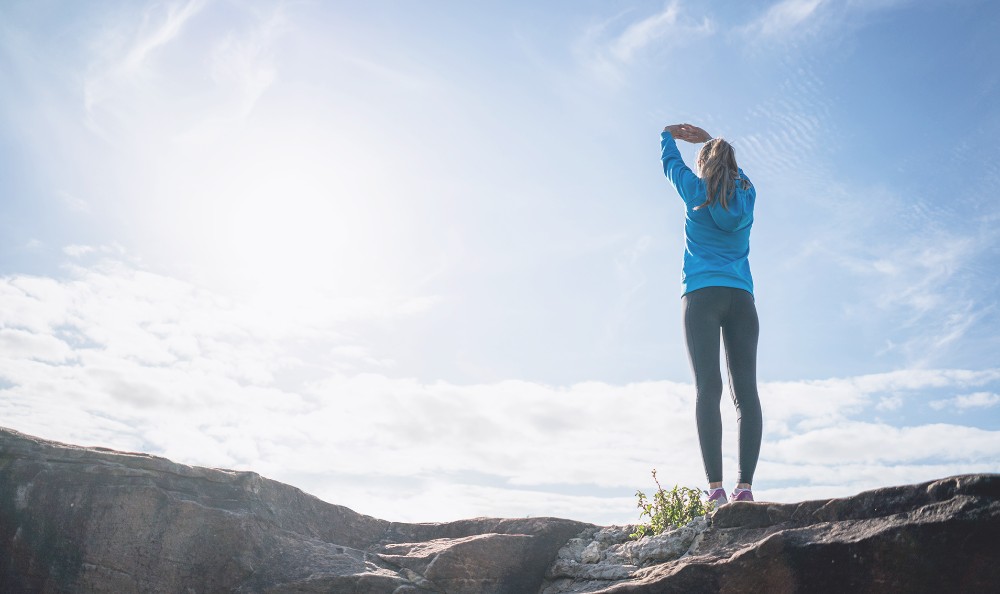 Girl Stretching Infront of light in a sky background